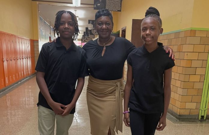  assistant principal posing with 2 7th grade students